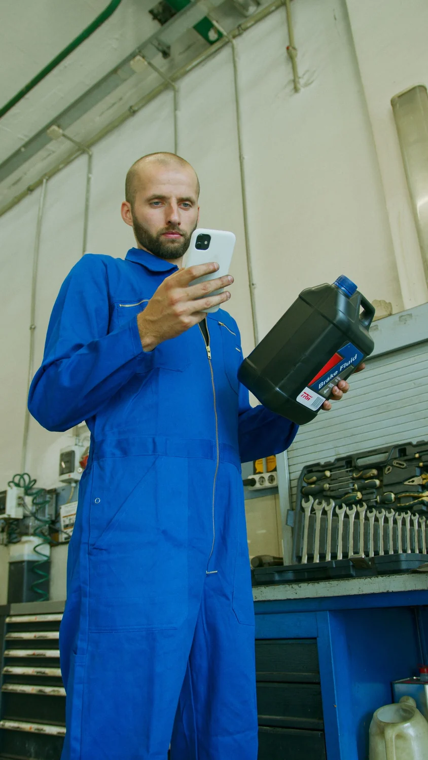 Monteur in een technische werkplaats met een smartphone